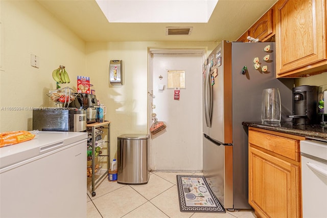 kitchen featuring stainless steel fridge, light tile patterned floors, white dishwasher, and fridge