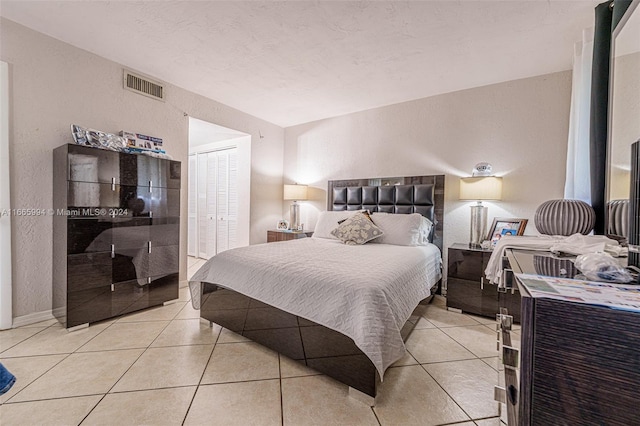 bedroom with a closet and light tile patterned flooring