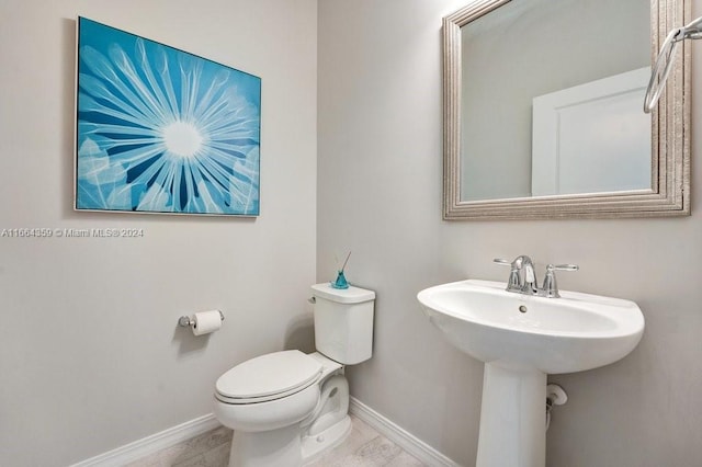 bathroom featuring wood-type flooring, toilet, and sink