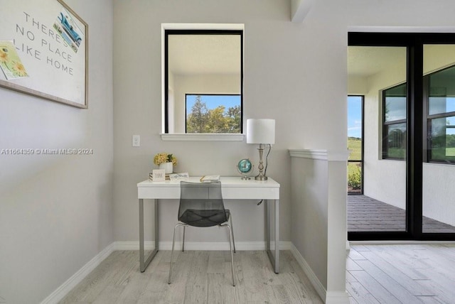 home office with light hardwood / wood-style flooring