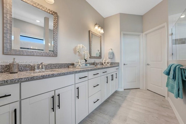 bathroom with hardwood / wood-style flooring, a shower with door, and vanity