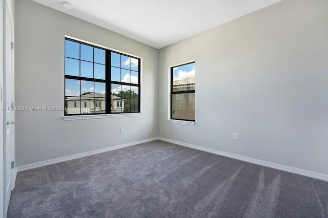 spare room featuring dark carpet