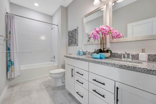 full bathroom featuring hardwood / wood-style floors, vanity, shower / bath combo, and toilet