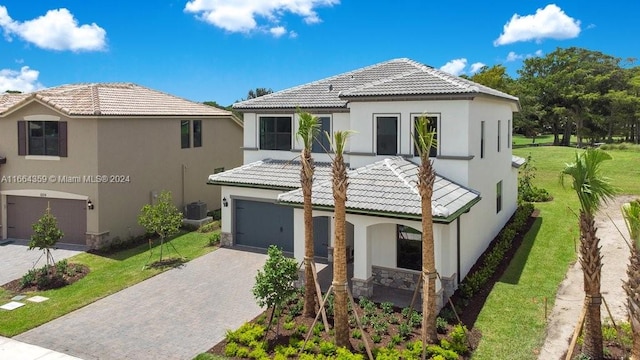 view of front of property featuring a garage, central AC unit, and a front lawn