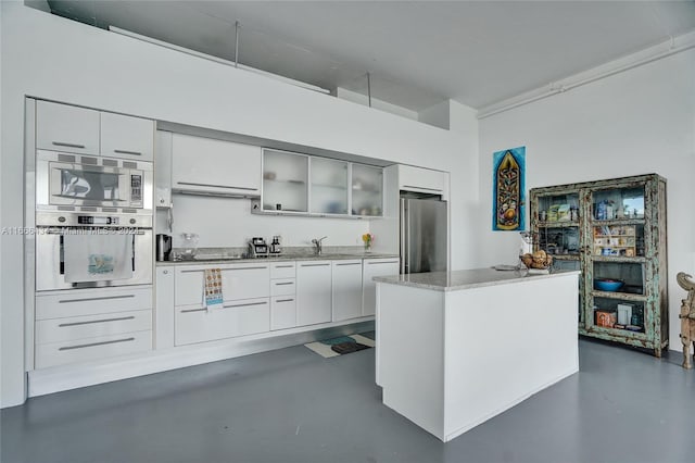 kitchen featuring appliances with stainless steel finishes, sink, extractor fan, and white cabinetry