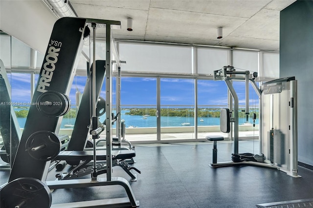 exercise room with a water view and floor to ceiling windows