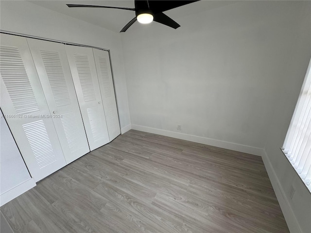 unfurnished bedroom featuring ceiling fan, a closet, and light hardwood / wood-style flooring