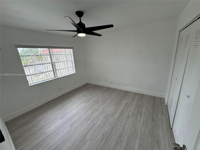 unfurnished bedroom featuring light hardwood / wood-style flooring, a closet, and ceiling fan