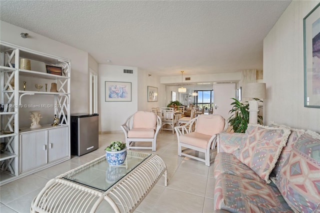 living room with a textured ceiling and light tile patterned floors