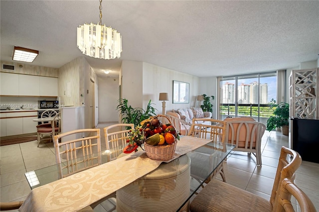 tiled dining area featuring a chandelier and a textured ceiling