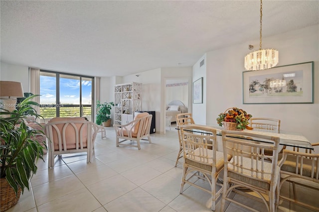 dining room featuring a notable chandelier, a textured ceiling, and light tile patterned floors