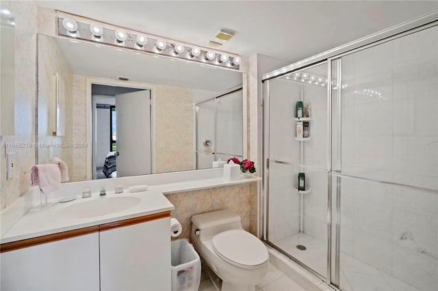 bathroom with walk in shower, vanity, toilet, and tile patterned floors