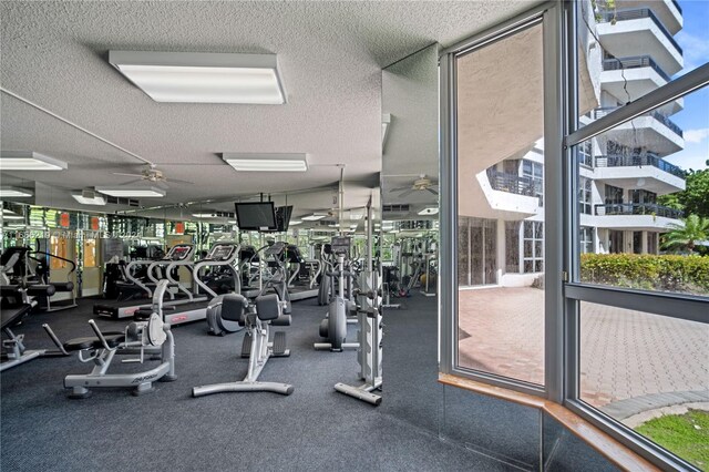 exercise room with ceiling fan, a textured ceiling, and floor to ceiling windows