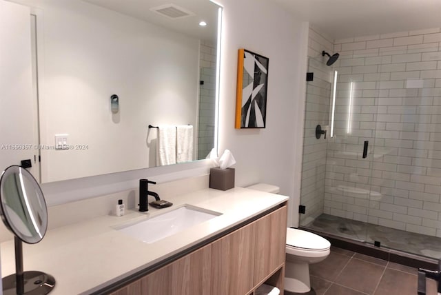 bathroom with tile patterned flooring, walk in shower, vanity, and toilet