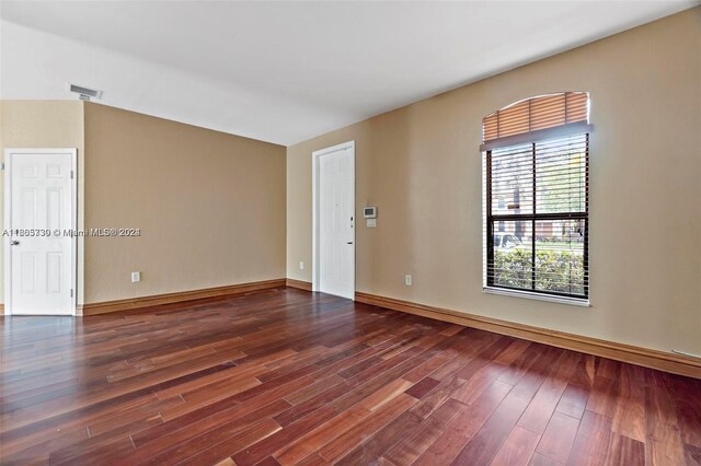 unfurnished room with dark hardwood / wood-style floors