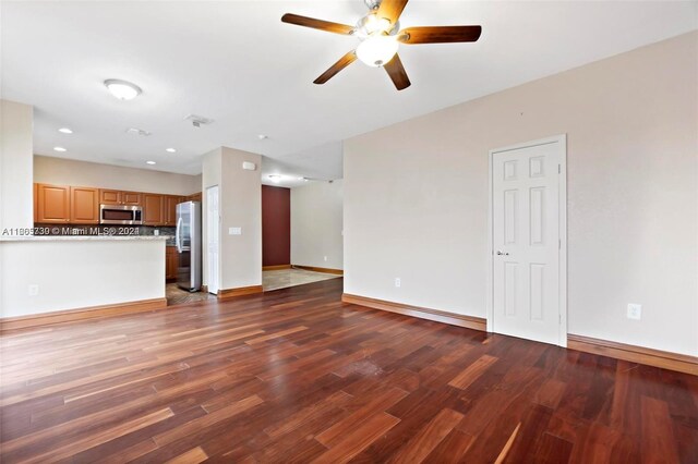 unfurnished living room with ceiling fan and dark hardwood / wood-style flooring