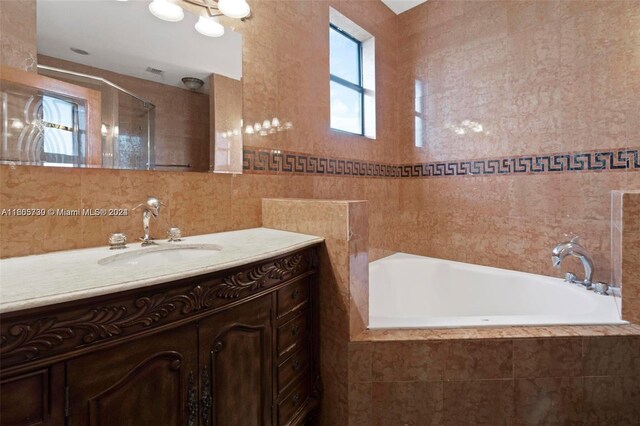 bathroom with tile walls, vanity, and plus walk in shower