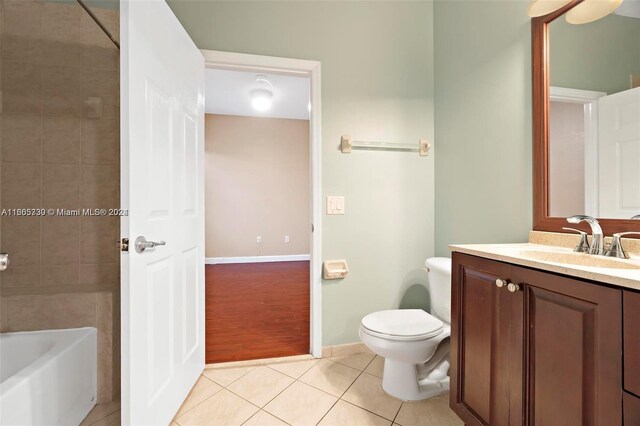 full bathroom featuring wood-type flooring, tiled shower / bath combo, vanity, and toilet