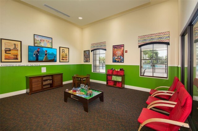 game room featuring dark colored carpet and crown molding