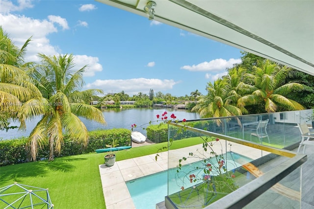 view of swimming pool with a water view and a lawn