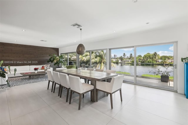 dining area with wood walls and a water view