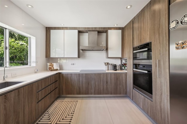 kitchen with sink, wall chimney exhaust hood, black appliances, and light tile patterned floors