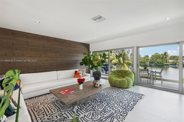 living room featuring wooden walls and a water view