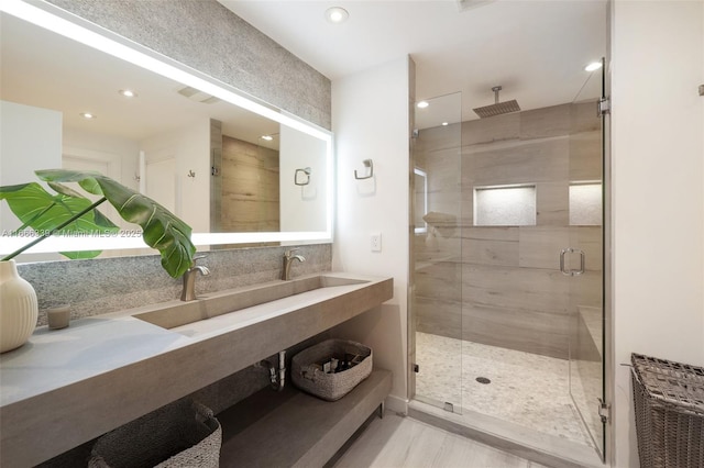 bathroom featuring wood-type flooring and an enclosed shower