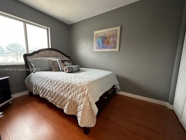 bedroom with dark hardwood / wood-style flooring