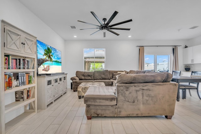 living room featuring ceiling fan and light hardwood / wood-style floors