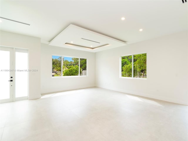 empty room with a wealth of natural light and a tray ceiling