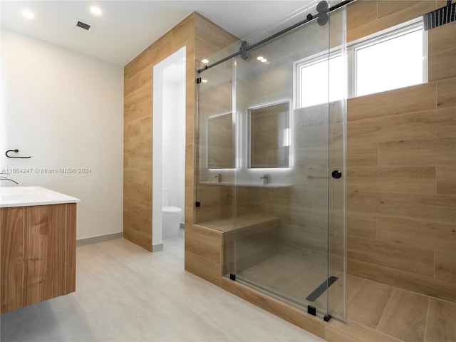 bathroom featuring vanity, toilet, and an enclosed shower