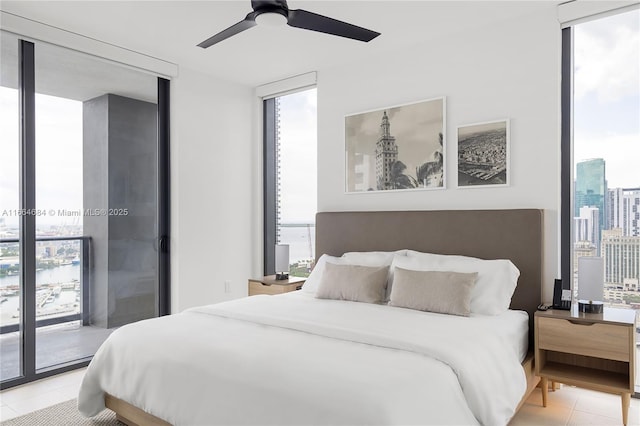 bedroom featuring ceiling fan, access to outside, a wall of windows, and light tile patterned floors