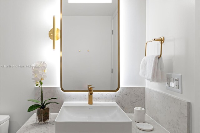 bathroom featuring tasteful backsplash, sink, and toilet