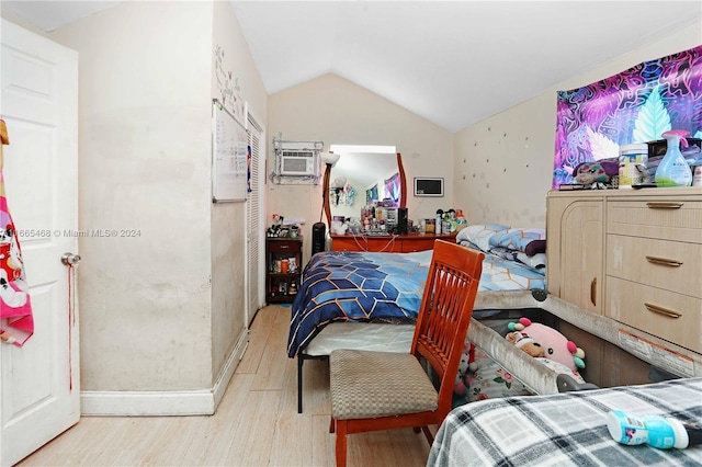 bedroom featuring light wood-type flooring, lofted ceiling, and a wall mounted AC