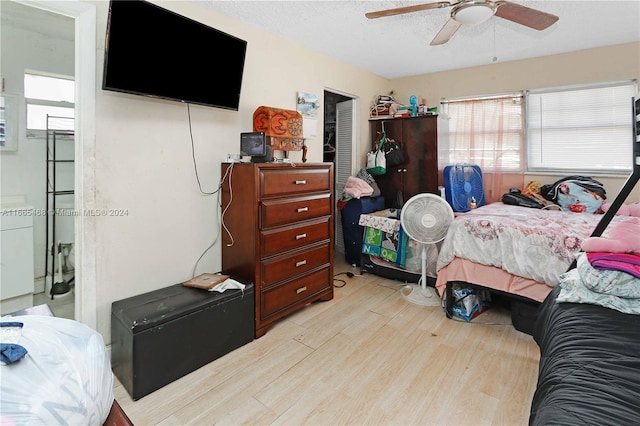 bedroom with light hardwood / wood-style flooring, ceiling fan, and a textured ceiling