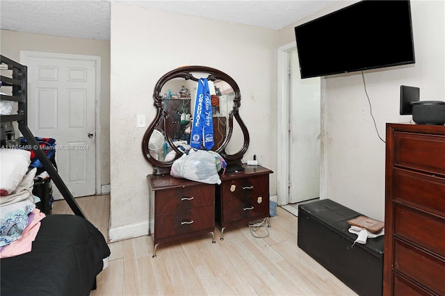 bedroom with light hardwood / wood-style floors and a textured ceiling