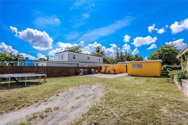 view of yard with a trampoline and a patio area