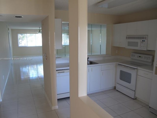 kitchen featuring white cabinets, white appliances, and light tile patterned floors