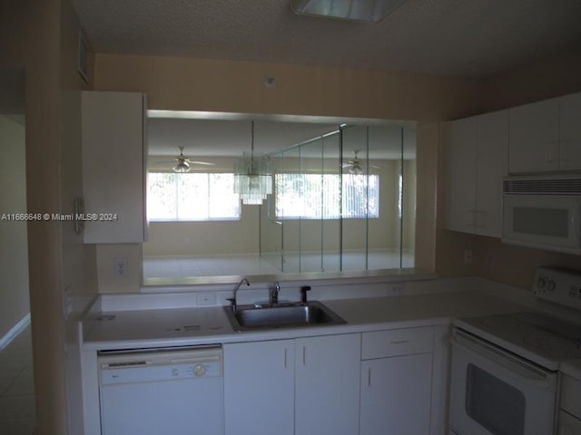 kitchen featuring ceiling fan, sink, white appliances, a textured ceiling, and white cabinetry