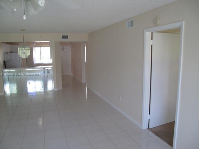9511 Weldon Cir Unit G215, Tamarac, FL 33321 - hallway with a textured ceiling, light tile patterned floors, and baseboards