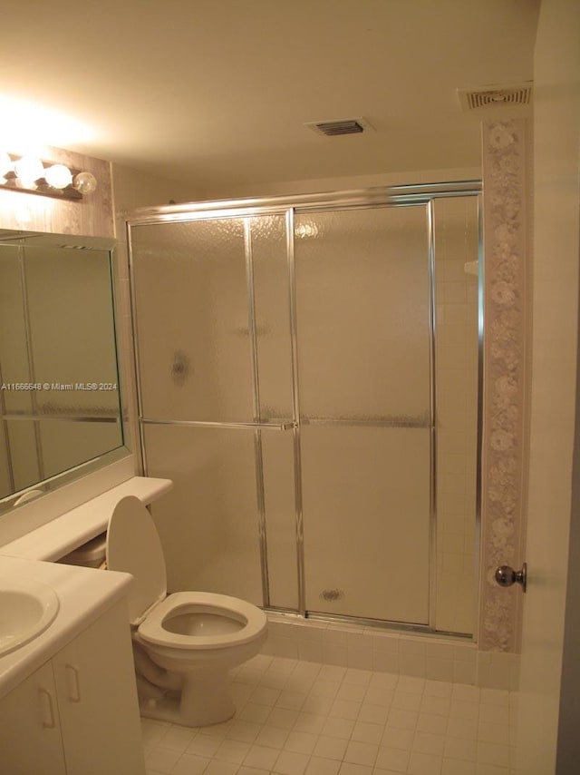 bathroom with tile patterned floors, walk in shower, vanity, and toilet