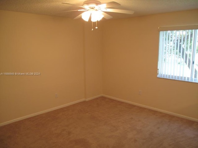 empty room with a textured ceiling, carpet, and ceiling fan