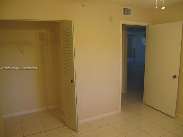 unfurnished bedroom with light tile patterned floors and a closet