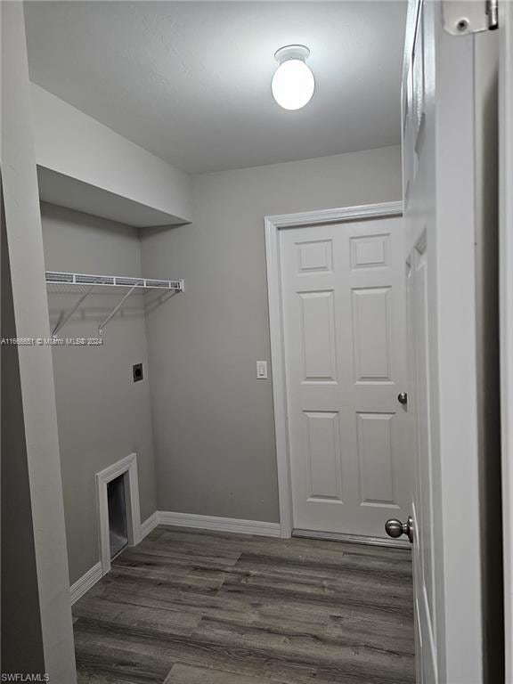 laundry room with a fireplace, dark wood-type flooring, and electric dryer hookup