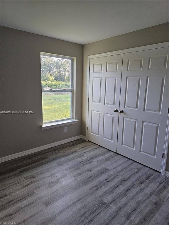 unfurnished bedroom featuring hardwood / wood-style flooring and a closet