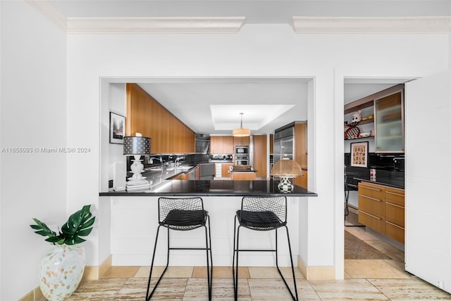 kitchen featuring stainless steel built in refrigerator, pendant lighting, ornamental molding, kitchen peninsula, and a kitchen bar