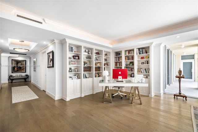 office with wood-type flooring, a tray ceiling, and ornamental molding