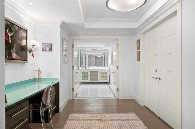 interior space featuring built in desk, crown molding, a tray ceiling, and dark hardwood / wood-style floors