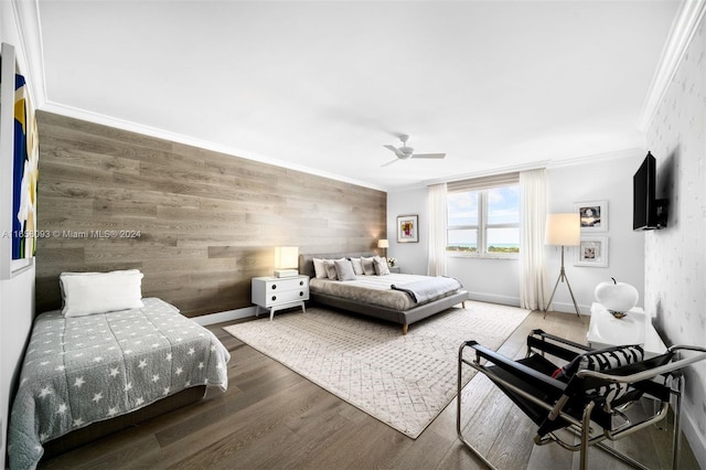 bedroom featuring ceiling fan, wooden walls, dark hardwood / wood-style floors, and ornamental molding